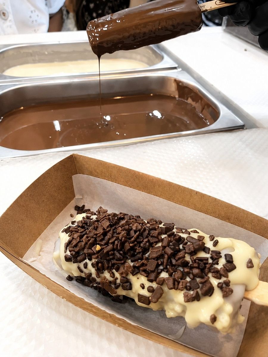 Picolé Skimo recebendo a cobertura de chocolate